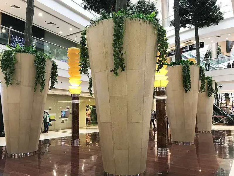 Stone-clad column and planters in a shopping mall